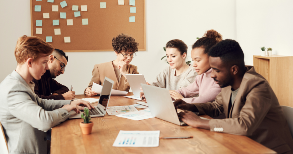 A group of people sitting around a table with laptops
AI-generated content may be incorrect.